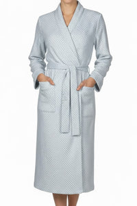 Woman wearing a light blue patterned robe on a white background